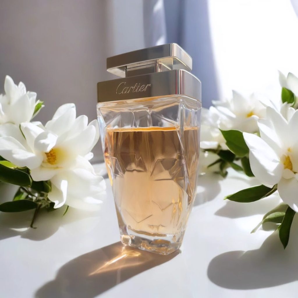 Cartier La Panthère Légère perfume bottle surrounded by white flowers in soft natural light